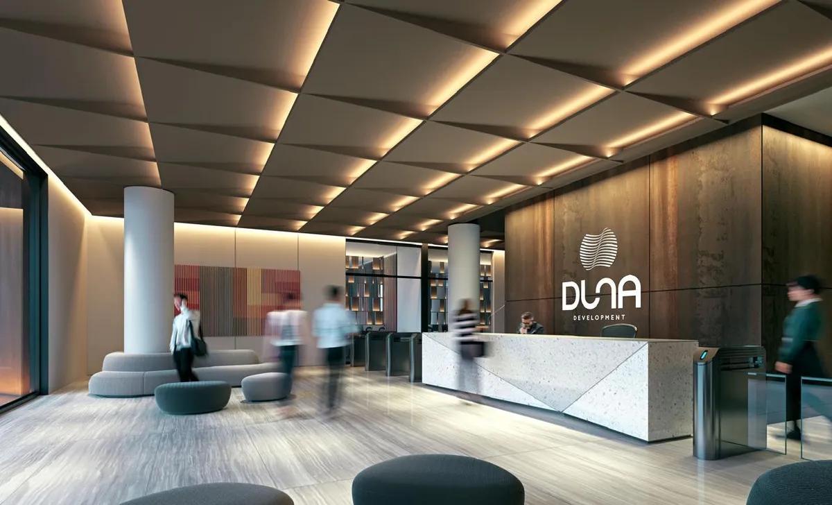 Rendering of a building lobby with a stone reception desk, access turnstiles and a cove-lit ceiling
